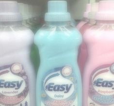 three bottles of easy fabric conditioner sitting next to each other in a store shelf