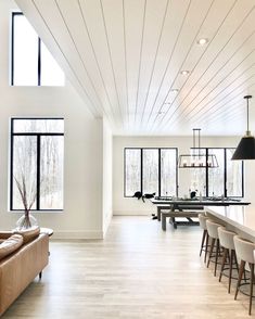 a large open living room with lots of windows and furniture in front of the pool table