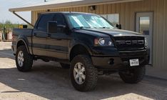 a black truck parked in front of a building