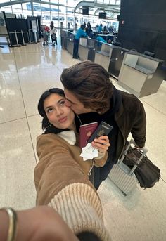 a man and woman kissing in an airport