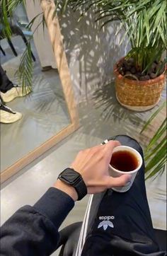 a person holding a cup of coffee in their hand