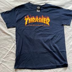 Authentic Classic Thrasher Flame Logo T-Shirt Size Men’s Large. The Iconic Thrasher Magazine Flame Logo Chest Graphic On A Dark Blue Color Way Made Of Durable Cotton Construction For A Comfortable Fit That Lasts. Never Worn/ New Without Tags Product Details Fabric Type 100% Cotton Closure Type Pull On Neck Style Crew Neck Sleeve Type Short Sleeve Blue Band Merch T-shirt With Logo Print, Blue Urban T-shirt For Fan Merchandise, Urban Blue T-shirt For Fan Merchandise, Blue Band Merch T-shirt With Logo, Blue Streetwear T-shirt With Back Print, Blue T-shirt With Back Print For Streetwear, Blue Band Merch Tops With Logo Print, Blue Band Merch Shirt For Streetwear, Blue Crew Neck Shirt With Band Merch