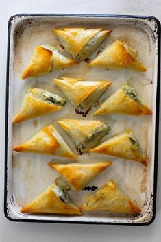 several pastries are arranged on a baking sheet and ready to go into the oven