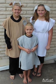 three children in costumes standing next to each other