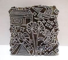 an intricately carved block with flowers and houses