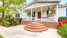 a white house with blue shutters and steps leading up to the front door is shown