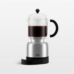 a glass coffee maker sitting on top of a white table next to a black lid