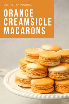 orange creamsice macarons on a white plate with the title overlay