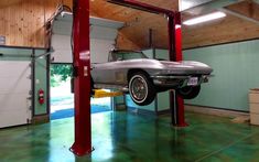 the car is parked in the garage with its lift attached to it's ceiling