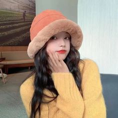 a woman with long hair wearing a yellow sweater and a brown hat is posing for the camera