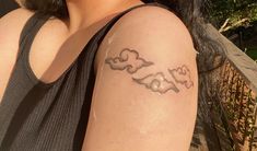 a woman with a tattoo on her arm that has clouds in the shape of hearts