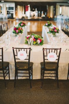 the tables are set up for a wedding reception with flowers and mr and mrs signs on them