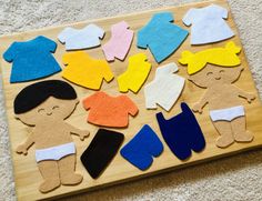 a wooden board with felt cut out of clothes on top of carpeted flooring