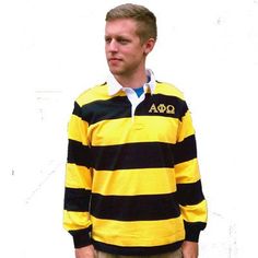 a man in a yellow and black striped shirt is standing with his hands in his pockets