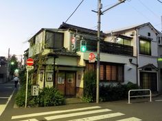 a street corner with an old building on the corner and traffic lights hanging above it