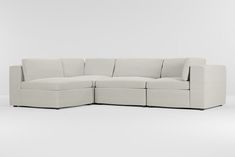 a white sectional couch sitting on top of a white floor