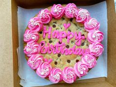 a birthday cake in a box with pink frosting