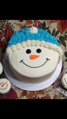 a snowman cake with frosting and decorations