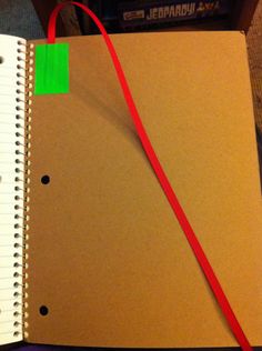 an open notebook with a red string attached to it