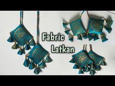 some blue and gold jewelry hanging from a hook on a white wall with the words fabric lakkan