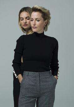 two women standing next to each other wearing black sweaters and pants with polka dots on them