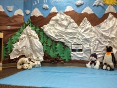 some stuffed animals are sitting on a sheet of paper in front of a bulletin board