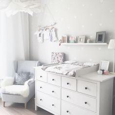 a baby's room with white furniture and decorations