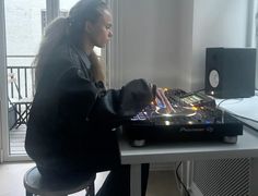 a woman sitting at a table with a dj mixer