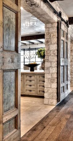 an open door leading to a kitchen with stone walls and flooring on the side