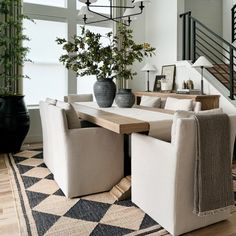 a dining room table surrounded by chairs and vases