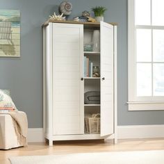 a white cabinet in a living room next to a window