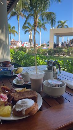 a plate full of food sitting on top of a wooden table next to a cup of coffee