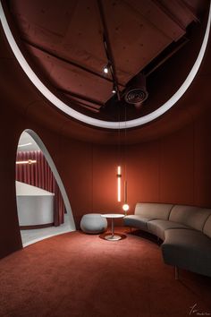 a living room with red walls and a circular light fixture hanging from the ceiling above it