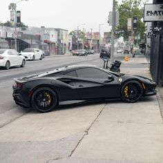 the black sports car is parked on the side of the street