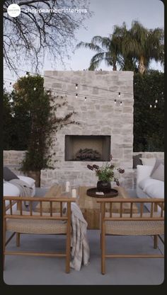 a living room filled with furniture and a fire place in front of a stone fireplace