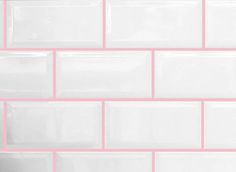 a pink and white tiled wall with some black tiles