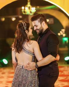 a man and woman standing next to each other on a dance floor