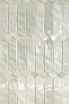 a close up view of a white tile wall that has been tiled in several rows