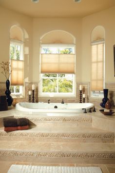 a large bath tub sitting next to two windows in a bathroom with beige walls and flooring