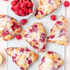 raspberry muffins on a white tray with fresh raspberries