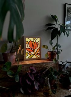 a lamp that is on top of a table next to plants and potted plants