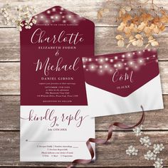 the wedding stationery is set on top of a wooden table with flowers and ribbon