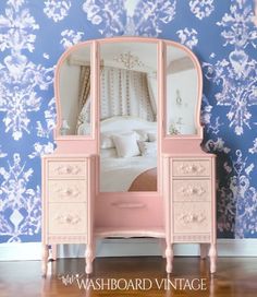 a pink dresser with a mirror on top of it