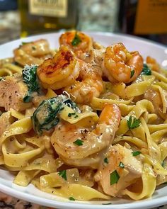 pasta with shrimp and spinach on a white plate