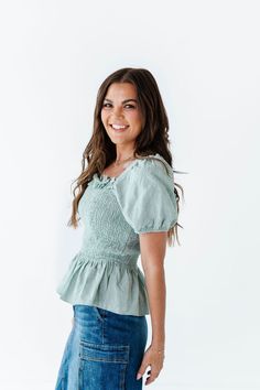 Features Square neckline with ruffle detailing Short sleeve with elastic Smocked bust Sage color 100% Cotton Size + Fit Small 0-4, Medium 4-8, Large 8-12 Kristin is 5'4", a size 1 and is wearing a Small Runs true to size Click here for skirt shown in photos Casual Smocked Dress With Ruffle Sleeves, Casual Puff Sleeve Top With Smocked Cuffs For Fall, Casual Smocked Dress With Ruffle Hem And Sleeves, Casual Fitted Smocked Dress With Ruffle Sleeves, Fall Smocked Bodice Puff Sleeve Top, Fitted Ruched Smocked Top With Ruffle Sleeves, Fitted Smocked Top With Ruched Ruffle Sleeves, Casual Puff Sleeve Top With Ruffle Sleeves For Spring, Casual Puff Sleeve Top With Ruffle For Spring