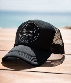 a black trucker hat sitting on top of a wooden table