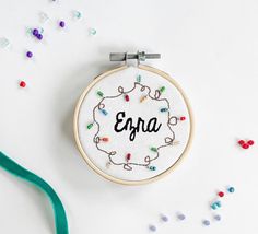 an embroidered hoop with the word efra on it next to confetti sprinkles