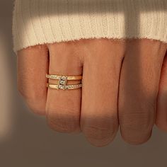 a woman's hand with two gold rings on it