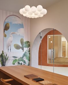 a wooden table sitting under a large mirror next to a wall mounted bird on it