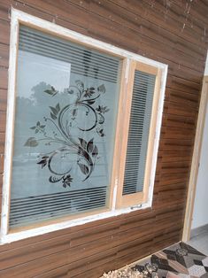 an old window is being painted on the side of a wooden building with decorative designs